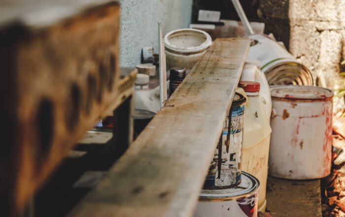 Pollutants such as old paint, chemicals, and more all piled up in a cement room